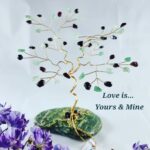 Decorative wire tree sculpture with green and dark beads on a mossy rock base; includes the message 'Love is... Yours & Mine'.