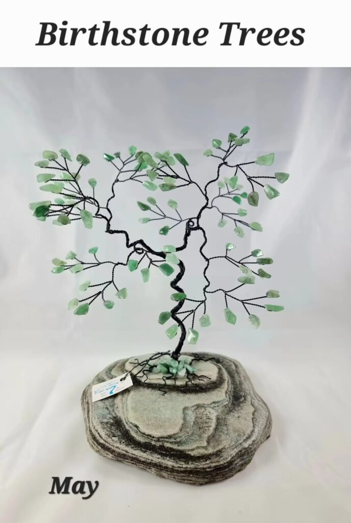 birthstone tree 1 Emerald-green gemstone leaves form a wire-tree sculpture planted in a layered stone base.